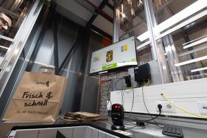 Das System kombiniert firmeneigene Lagersoftware, AutoStore-Automatisierung, robotergestützte Kommissionierung und lebensmittelspezifische Bestandsintelligenz über mehrere Temperaturzonen hinweg