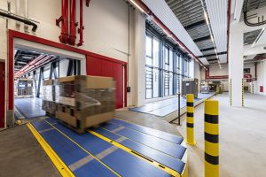 Über das automatisierte Transportsystem fährt die Palette mit Wellpappe   von der Produktionshalle über eine 40 Meter lange Brücke direkt in das Hochregallager